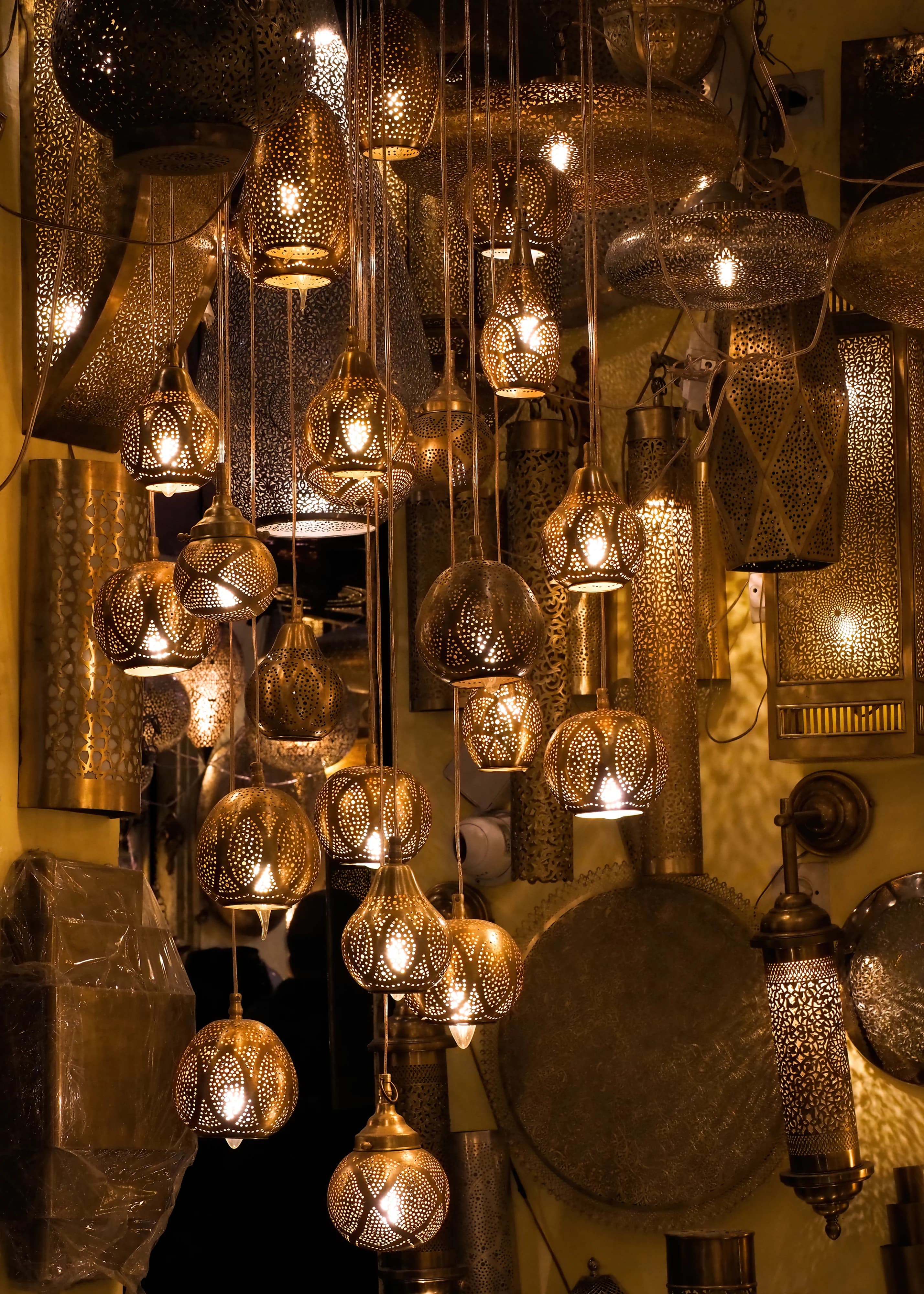 Dozens of pierced metal lanterns hang closely together in a workshop in Marrakech medina.